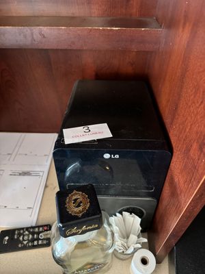 a bottle of alcohol sitting on a counter next to a remote control