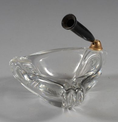 un cendrier en verre avec une poignée noire sur fond blanc