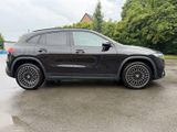 the mercedes gle is parked in a parking lot in front of a house