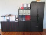 une armoire noire sur laquelle sont posés plusieurs classeurs
