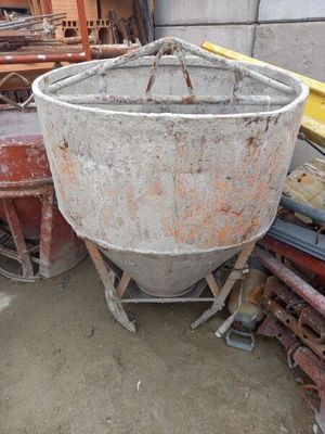 a cement mixer sitting in the middle of a pile of junk