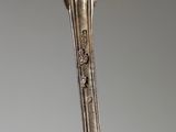 a close up of a silver spoon with a flower on it