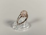 un gros plan d'une bague en diamant posée sur un socle transparent
