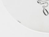 a drawing of a clock on a plate on a table