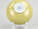 yellow vase with a blue and white design on the top