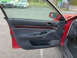 a red car with its door open in a parking lot