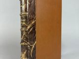 un vieux livre à la couverture brune posé sur une table