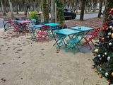 de nombreuses tables et chaises près d'un sapin de Noël sur le trottoir