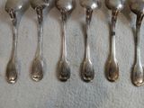 six cuillères alignées sur une table
