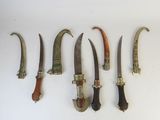 five different types of knives are lined up on a white surface