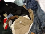 a pile of clothes that is sitting on a bed