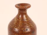 a brown vase that is sitting on a white surface