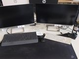 trois écrans d'ordinateur et un clavier posés sur un bureau