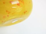 a yellow vase sitting on a table with a white background