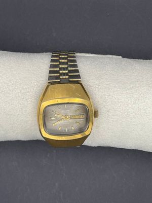 une montre-bracelet posée sur une serviette blanche, sur une surface noire