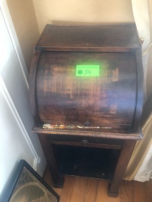 un petit meuble en bois sur lequel est posée une lampe verte