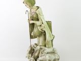 figurine of a shepherd with sheep and lambs in a basket