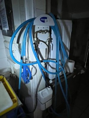 une photo d'une salle de bains avec de nombreux tuyaux fixés au mur