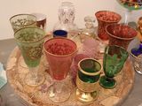 many different colored glasses on a tray on a table