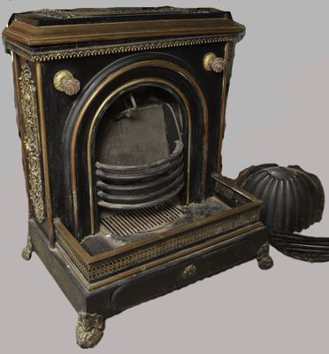 une cheminée noire et dorée surmontée d'une horloge