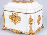a white and gold casket with a gold decoration on the top