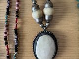 many necklaces and bracelets that are on a table