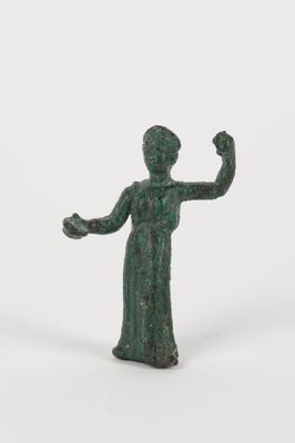 une petite statue représentant une femme la main levée
