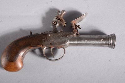un vieux pistolet posé sur une table