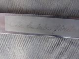 a close up of a knife with writing on it