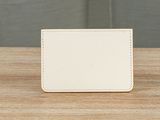 a white card holder sitting on top of a wooden table