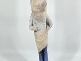 figurine of a pig in a sweater and jeans standing on a wooden base