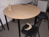 a table and chairs in a small room with a refrigerator