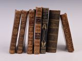 plusieurs vieux livres sont empilés sur une surface blanche