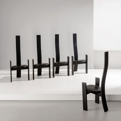 Plusieurs chaises noires sont alignées en rangée dans une pièce blanche
