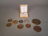 une petite boîte contenant des pièces et une médaille, posée sur une table