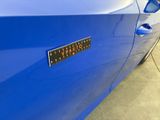 a close up of a blue car with a sticker on it
