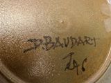 a brown vase with writing on it sitting on a table