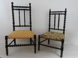 pair of antique black painted chairs with yellow upholstered cushions