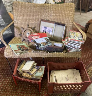 une chaise en osier sur laquelle est posé un panier rempli de livres