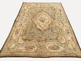 un tapis ancien orné d'un grand motif floral sur fond blanc