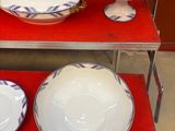 trois bols et deux assiettes sur une étagère rouge