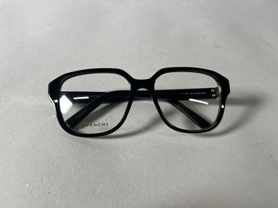 une paire de lunettes posée sur une table, sur fond blanc