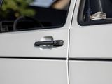 a close up of a car door handle with a bottle of wine in it