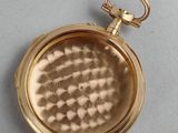 an old gold pocket watch with a chain hanging from it ' s side