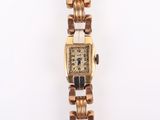 an image of a gold watch with a black and white face