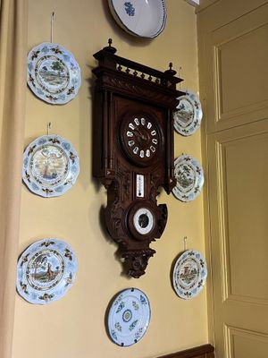de nombreuses assiettes accrochées au mur et une horloge accrochée au mur