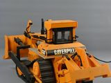 a toy bulldozer that is sitting on a gray surface