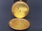 a gold pocket watch that is open on a black surface