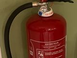 un extincteur à côté des toilettes dans une salle de bains