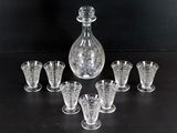 six verres et une carafe posés sur une table